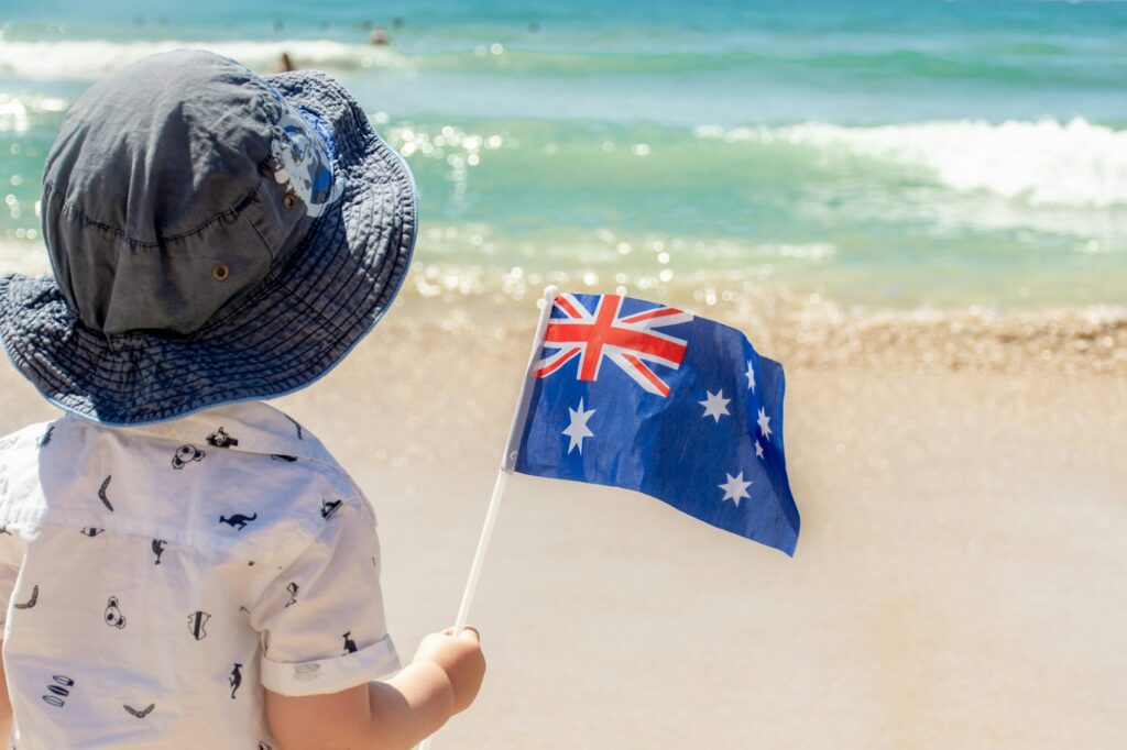 Little boy with Australian flag near the ocean. Australia Day concept